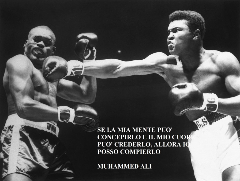 foto in bianco e nero di Mohamed Ali che colpisce con un pugno al mento l'avversario. Sulla foto compare la sua frase "se la mia mente può concepirlo e il mio cuore può crederlo, allora io posso compierlo" Un ìa lezionie di vita.