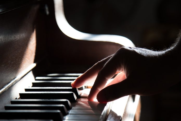 mano sulla tastiera di un pianoforte