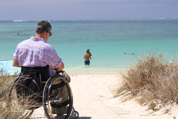 disabile in sedia a rotella sulla spiaggia