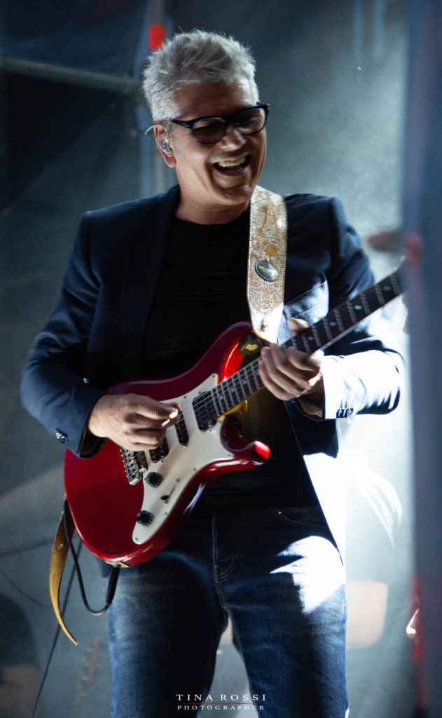 Vicere e rinascere tour - Michele Zarrillo sorridente con una chitarra rossa, suona al concerto del parco dora