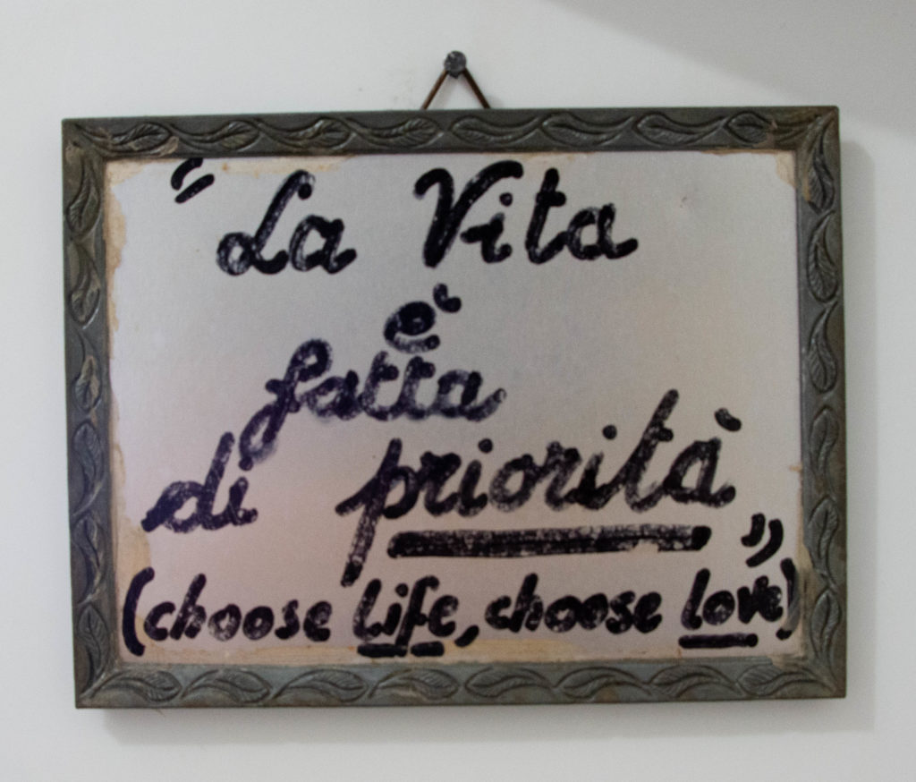 cornice d'argento con una scritta: la vita è fatta di priorità. Choose life, choose love"