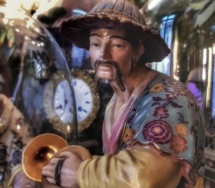 una porcellana presente nel negozio Marco Polo, un cinese con un tipico cappello tiene in mano due piattini da gong