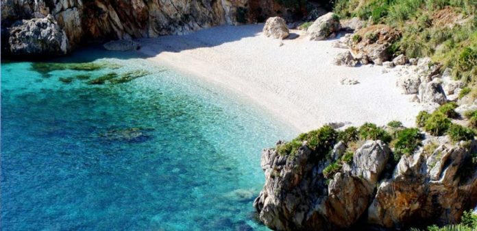 una spiaggia in sicilia in uninsenatura con il mare blu bellissimo e la sabbia bianchissima