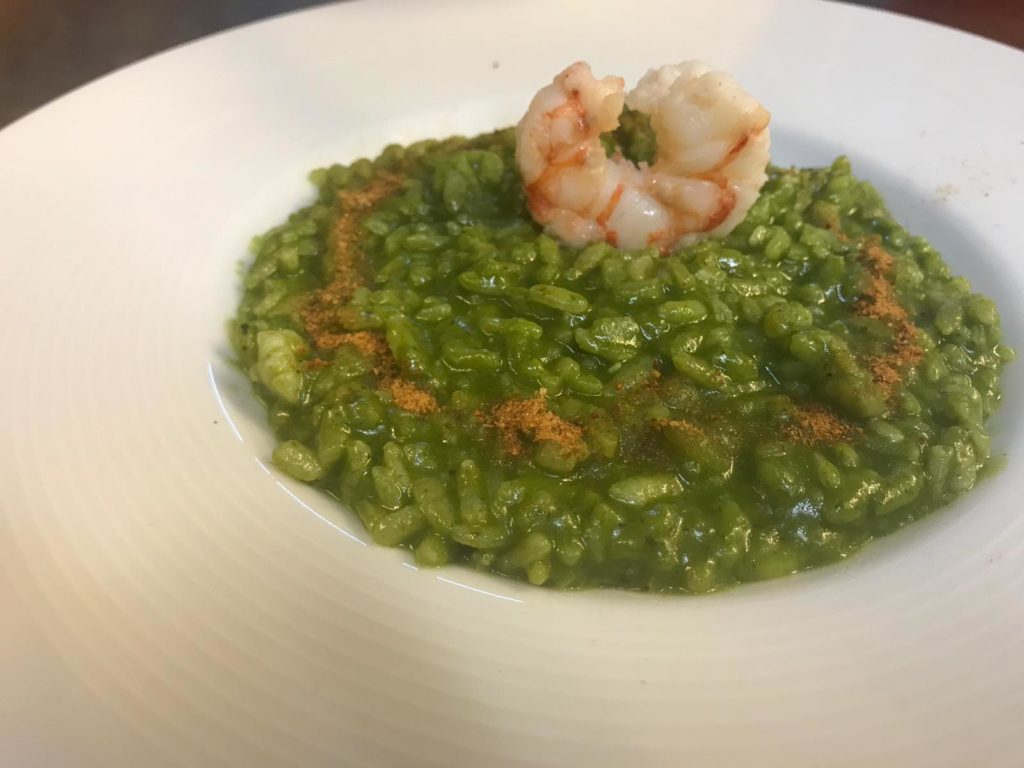 Pasta che passione! nella foto un piatto di risotto di colore verde con asparagi di mare e gamberoni freschi