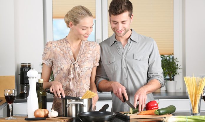 MASTERCHEF? NO, MASTERSCHIF! una donna a sinistra e un uomo a destra, in cucina, intenti a tagliare le verdure