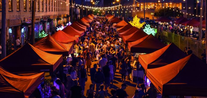 un mercato pieno di bancarelle con gente che fa shopping