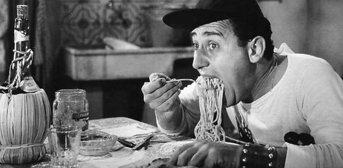 la sindrome da all inclusive rappresentata dalla famosa immagine di alberto Sordi che mangia gli spaghetti, nel film un americano a Roma
