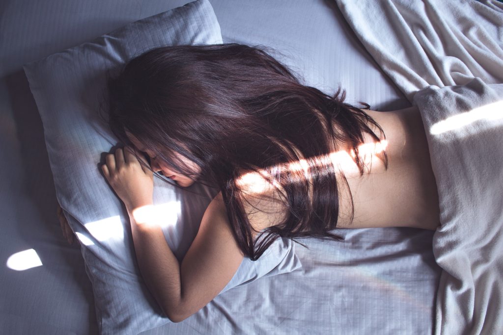 una donna a letto con un raggio di sole che la illumina