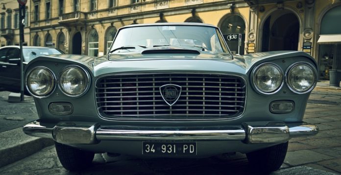 MOTORI & SAPORI AL TROMPONE’, in primo piano il muso di una Lancia flavia, di colore grigio, del 1964