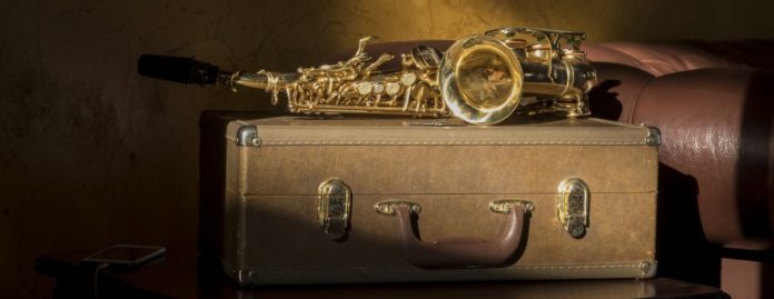 John Coltrane night: primo piano di un sassofono posato sopra una vecchia valigia