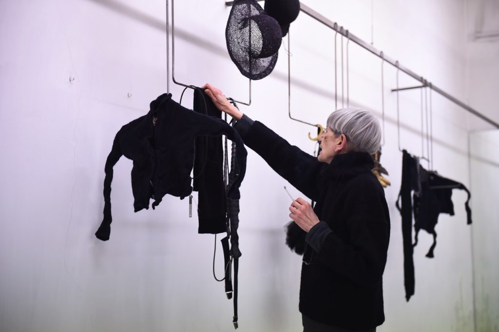 Boutique una donna vestita di nero appende abiti neri