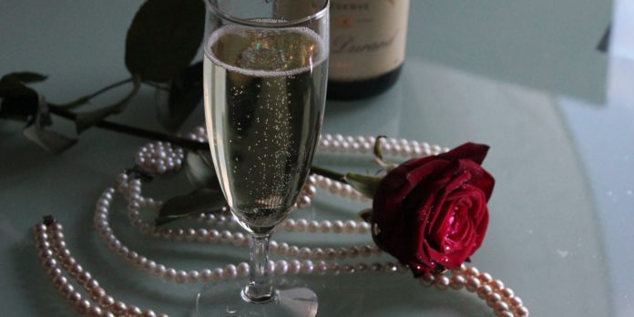 un flute di champagne una collana di perle e una rosa rossa per una serata di tentazione