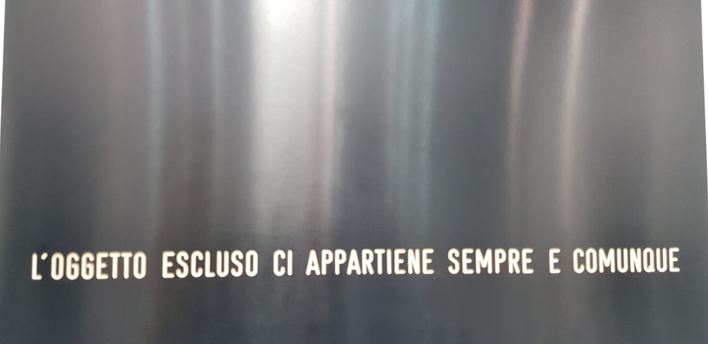 Fondo grigio con la scritta l'oggetto escluso ci appartiene sempre e comunque