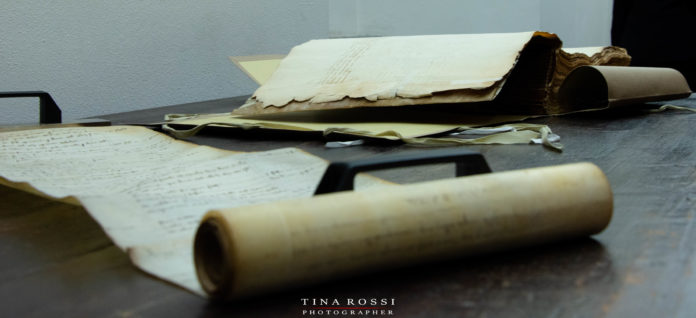 negli armadi della Memoria e della storia c'è una pergamena srotolata su un tavolo nella sezione Rotary 2031
