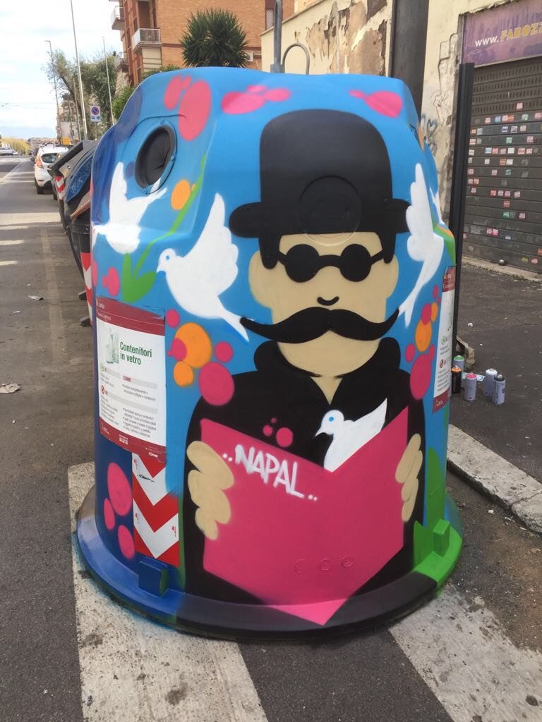 opera di street art. Una colorata decorazione di un cassonetto per la raccolta del vetro, raffigurante un uomo baffuto con un cappello a bombetta e occhiali da sole tondi che legge un giornale circondato da colombe bianche e