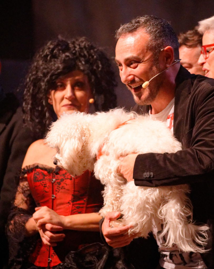 Claudio Insegno, regista del musical Sweeney Todd,con il suo cane in  braccio. Ha l 'archetto alla bocca e sorride