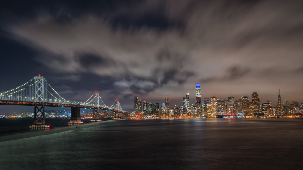 una veduta di San Francisco in una foto di matteo bertetto che in un intervista ci spiega la sua tecnica per fotografia moderna Il ponte illuminato e la città sullo sfondo, un cielo notturno quasi apocalittico