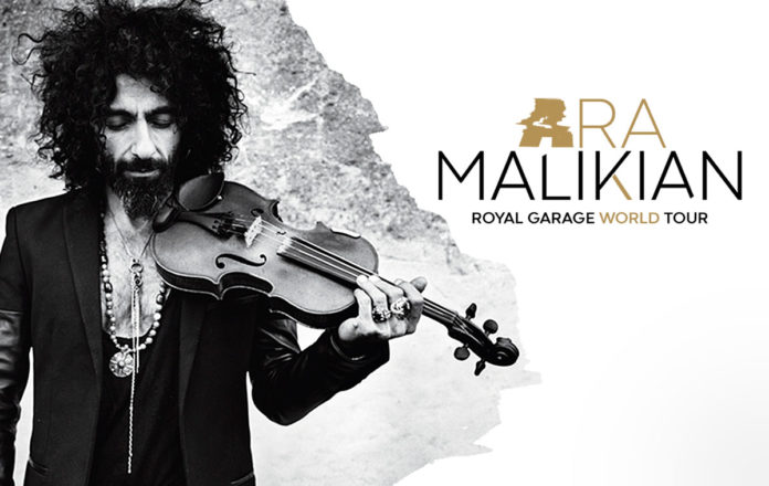Locandina del Royal Garage Tour di Ara Malikian in una foto in bianco e nero dove lui tiene il violino sulla spalla, vestito con giacca scura, lunghi capeli arruffati e folta barba nera, lo sguardo rivolto verso il basso
