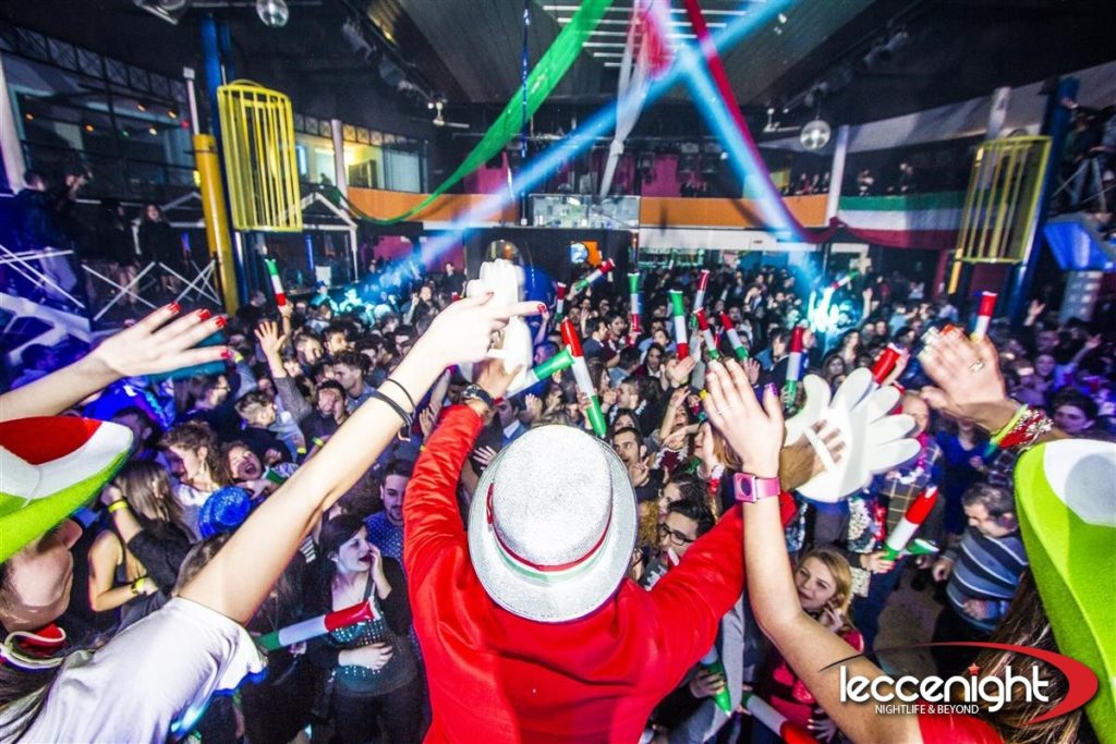 Capodanno in discoteca piena di gente che sventola tubi tricolore italiano