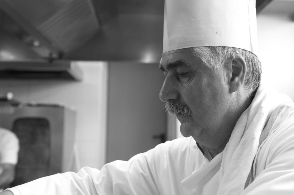 Capodanno 202 by chef Fontana: primo piano dello chef, foto in bianco e nero, intento a lavorare in cucina