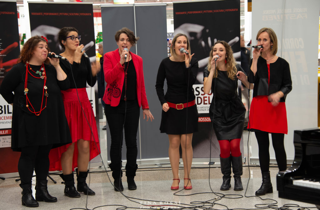 le Vocal Boutique vestite di rosso e nero mentre cantano a cappella dal vivo