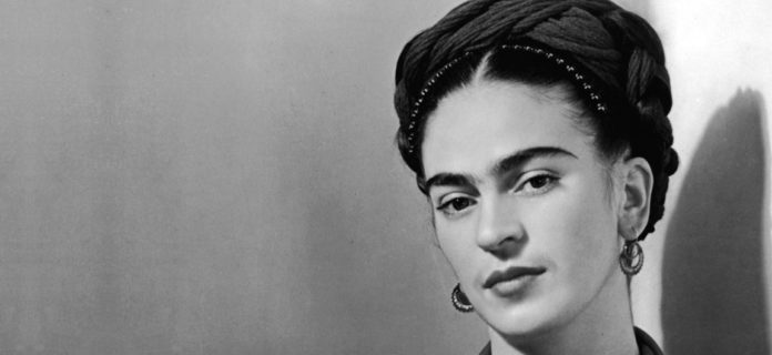 profilo di Frida Kahlo in bianco e nero, la testa inclinata, con capelli raccolti in una fascia intrecciata