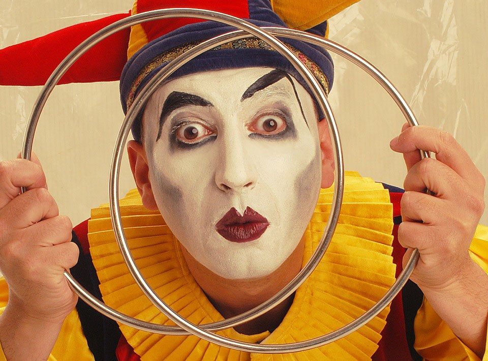 Marco Aimone, il filo conduttore dello show di magia, nelle vesti di giullare, con una smorfia e gli occhi sgranati, il suo viso dipinto di bianco compare tra due cerchi che tiene in mano