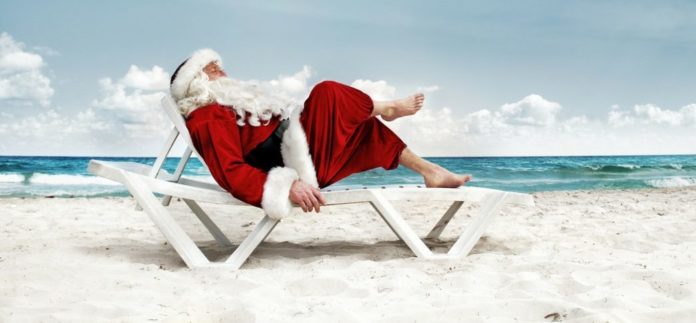 babbo natale seduto su una sdraio a spiaggia come canta la canzone di RDS feat BAZ natale reggaeton