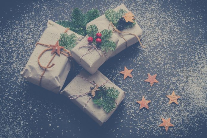 Dei pacchetti di regali di Natale contenenti dei libri acqusitati al Salone , con carta beige, con del viachio e delle stelline dorate di carta