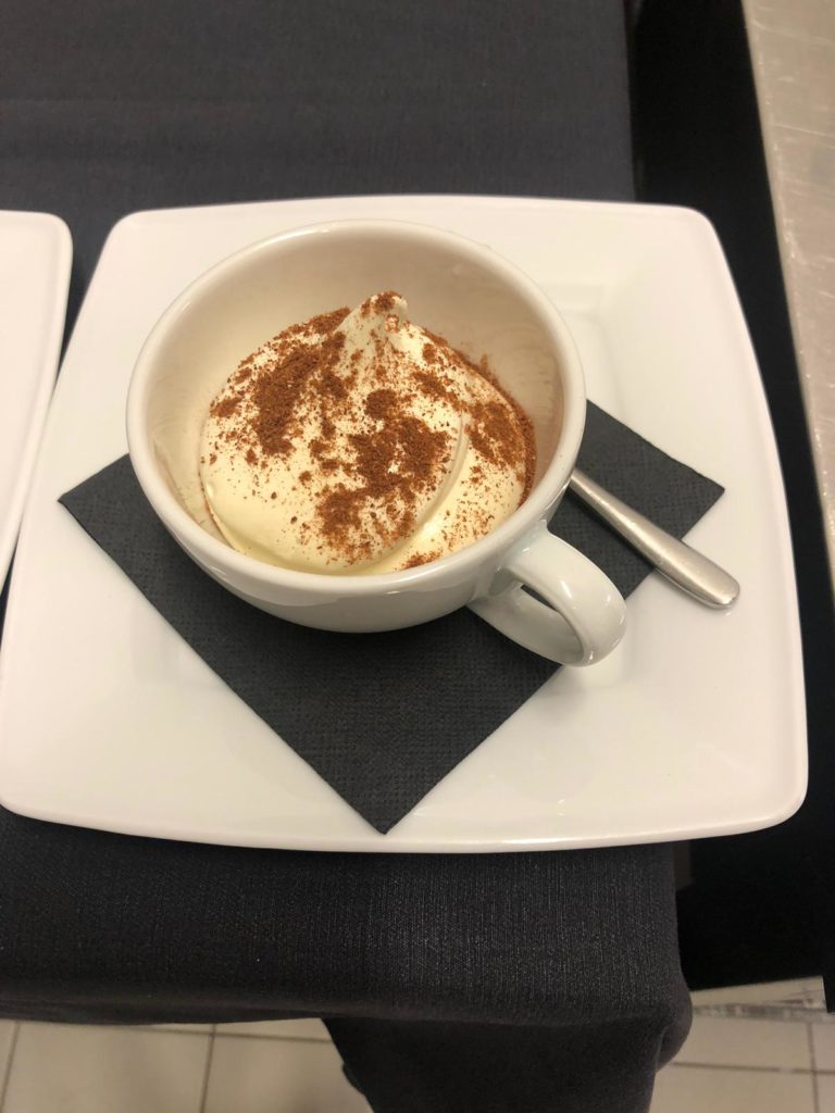 Sul tacolo di cucina dello chef Luca Pieroni, un dolce in tazza con polvere di cioccolato