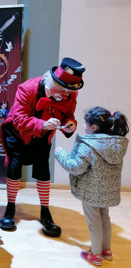 il clown Arturo fa un autografo a una bambina