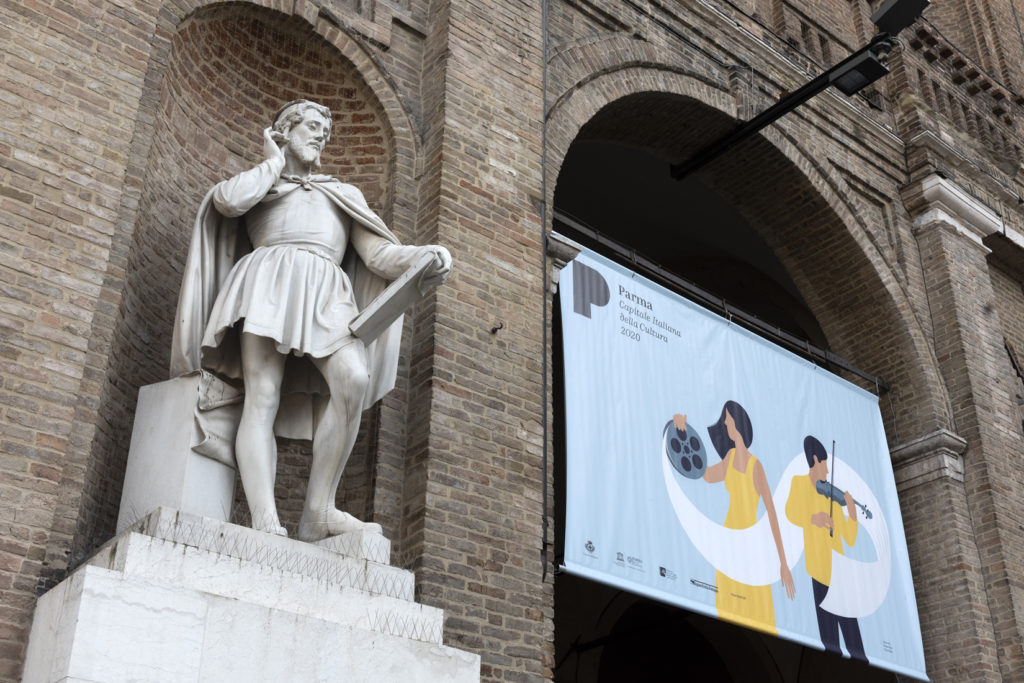  comunicazione e media in piazza con statua vicina