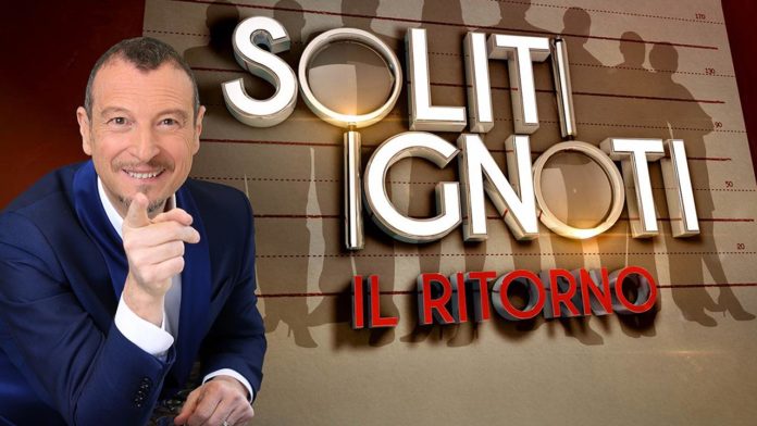 Sanremo 2020 Big Amadeus sorridente punta un dito verso l'obiettivo e dietro di lui la scritta i soliti ignoti il ritorno