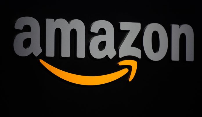 azienda amazon, simbolo di amazon, la scritta in grigio su sfondo nero, con la freccetta arancione sotto che parte dalla a e finisce sotto la z