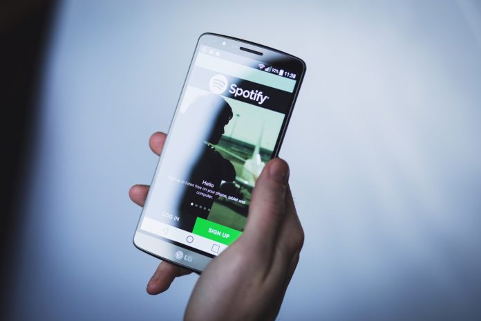 Spotify diventa Spotimatch: primo piano di una mano che regge uno smartphone