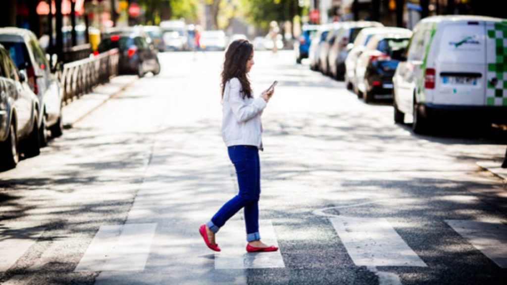 il pedone che attraversa la strada con il cellulare