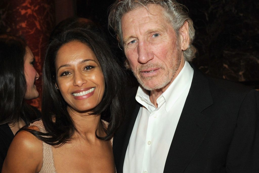 Rula Jebreal e Roger Waters, lei sorridente con abito scollato rosa, lui con camicia bianca e giacca nera