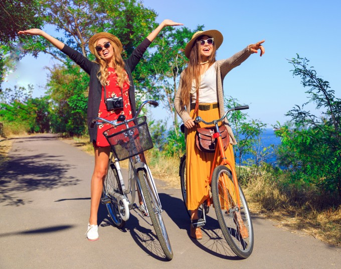 Due allegre e sorridenti ragazze bionde in sosta durante un giro in bici