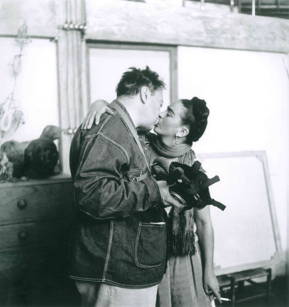 Frida Kahlo e Diego Rivera si baciano in piedi. Foto biancone nero 