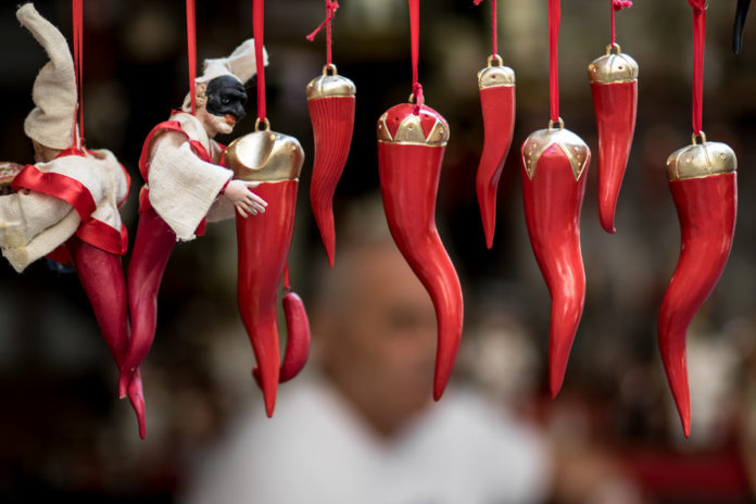 Napoli, cornetto. Nove cornetti rossi uno accanto all'altro, appesi con un filo di colore rosso. Ognuno di loro presenta in cima una coroncina color oro. I primi due possiedono inoltre la maschera di Pulcinella, caratteristica di Napoli.