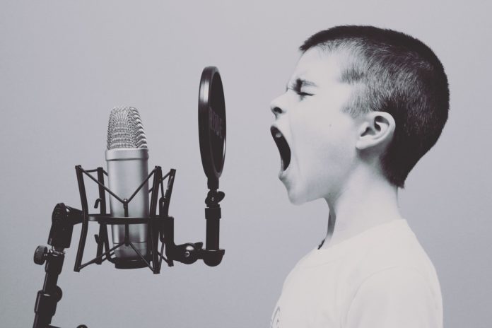 cover #sanremo70 un bambino canta con bocca aperta davanti ad un microfono