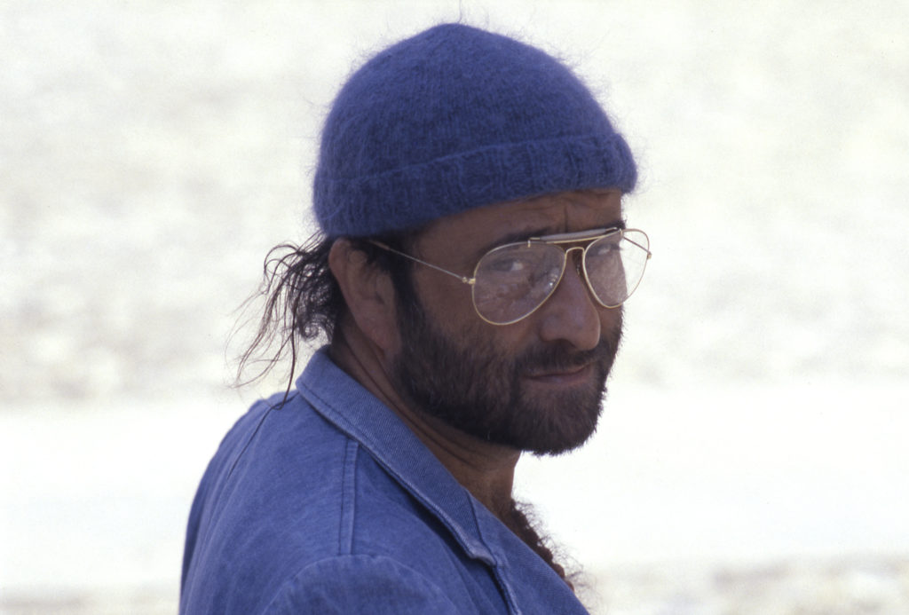 Lucio Dalla di profilo con cappellino blu occhiali a goccia e maglia blu