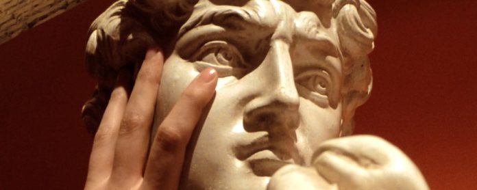 Percorso tattile per ciechi con abili per l'arte una mano tocca il viso di una statua di marmo bianco