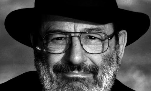 Umberto Eco in una foto in bianco e nero con cappello a falda larga, occhiali, barba e baffi