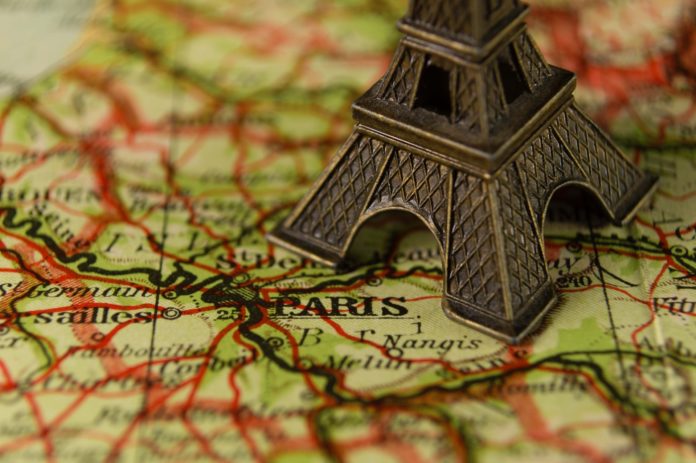 Un weekend a Parigi con una tour eiffel appoggiata sopra una cartina
