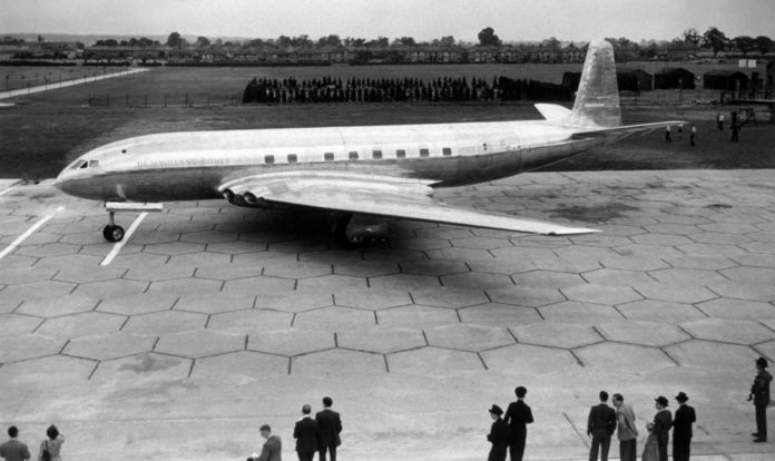 finestrini quadrati aerei, un aereo atterrato, con alcune persone davanti che lo osservano, foto in bianco e nero