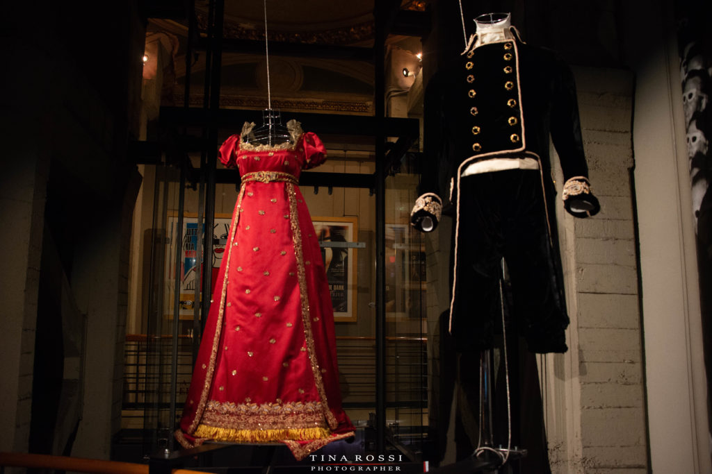 	Museo del Cinema di Torino - Cinemaddosso un abito lungo rosso da donna del 700 e un adivisa francese con pantamoni di velluto nero e giacca con doppi bottoni dorati