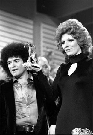 Sanremo 1974 Iva Zanicchi mostra il premio insieme a Cristiano Malgioglio. Foto in bianco e nero.