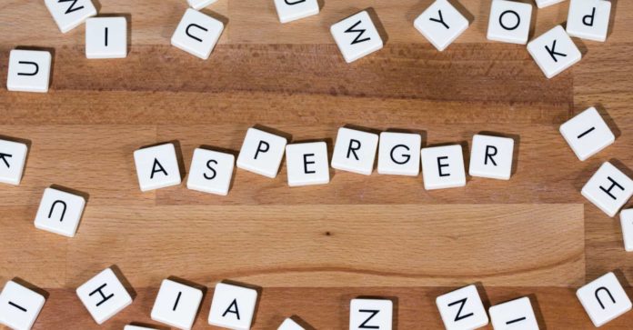 Sindrome di Asperger, 18 febbraio. Lettere, posizionate su un tavolo in legno, che formano la parola 
