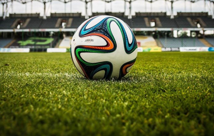consiglio federale FIGC: in primo pian un pallone, posato su un campo di calcio, all'interno di uno stadio vuoto